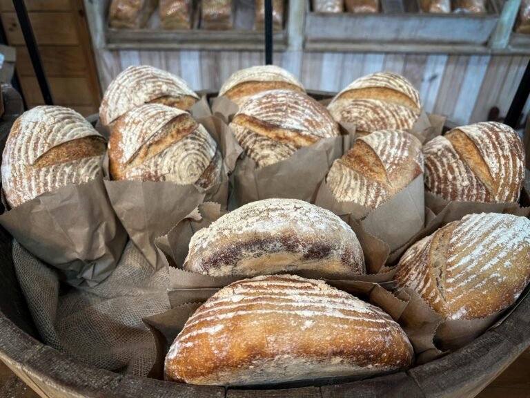 A collection of artisan sourdough loaves displayed in a rustic bakery setting.