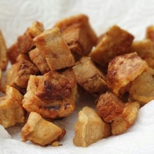 Delicious deep-fried pork bites on tissue paper, capturing their crispy texture and golden color.